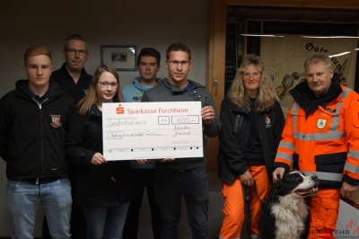 Scheckübergabe im Feuerwehrhaus Wiesenthau an die Rettungshundestaffel ForchheimIm Bild von links: Jugendsprecher Lukas Kari, 1. Vorsitzender Fw Wiesenthau Bernd Drummer; Jugendsprecherin Franziska Kaul; Jugendfeuerwehrmann Dominik Schulz, Jugendwart Stefan Uttenreuther; 1. Vorsitzedne RTH Forchheim Christine Bieringer; Zugführer RTH Kurt Lieb; Hündin Quin